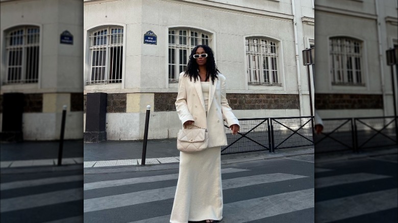 Woman wearing a white blazer, top, and skirt