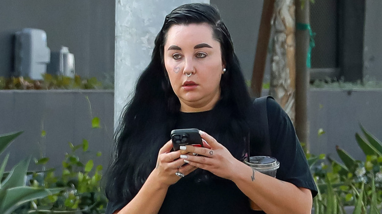 Amanda Bynes holds onto her phone with black hair