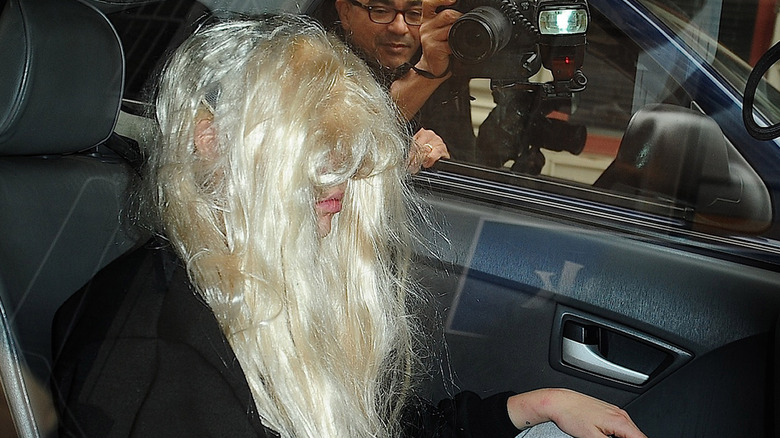 Amanda Bynes covers her face with a blond wig