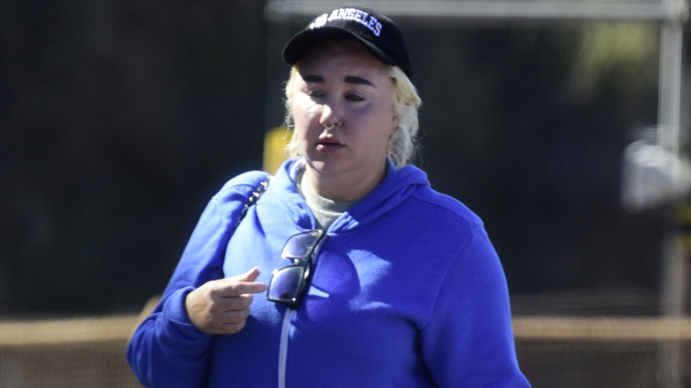 Amanda Bynes walks wearing a cap and blond hair