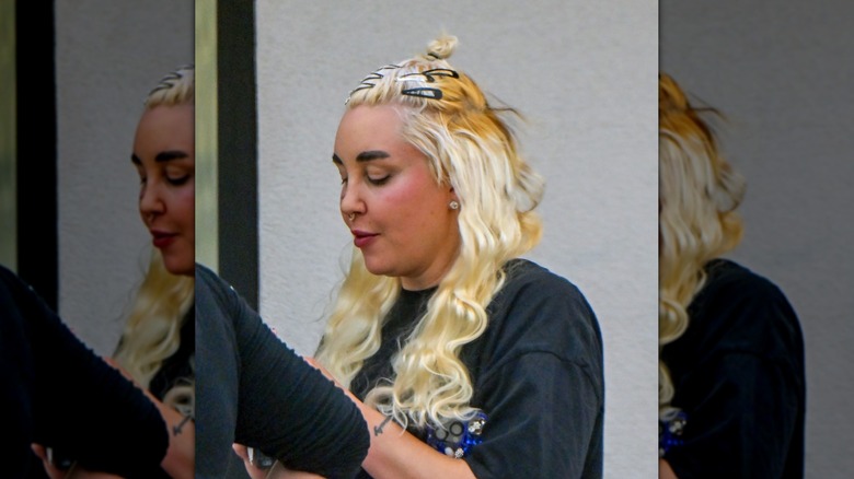 Amanda Bynes looks down wearing multiple clips in her blond hair
