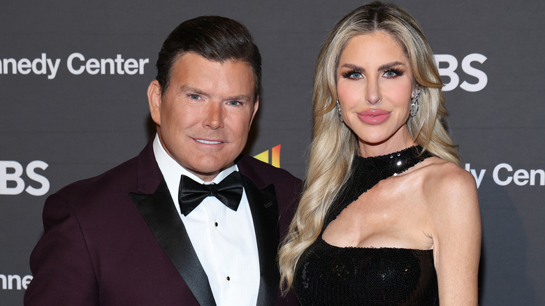 Amy Baier in a black sequin dress standing next to Bret Baier on the red carpet