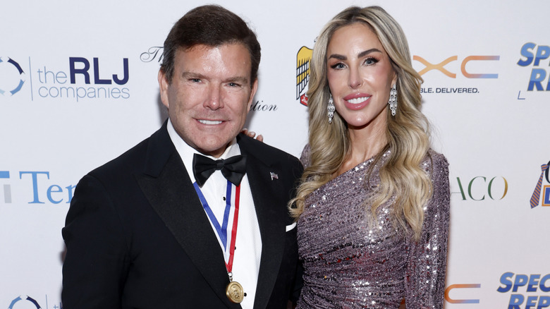 Amy Baier in a sequin dress standing next to Bret Baier on the red carpet