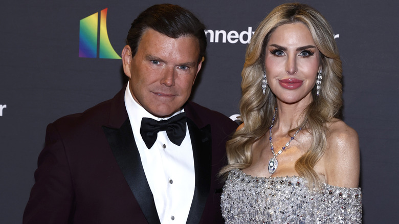 Amy Baier in a sequin dress standing next to Bret Baier on the red carpet