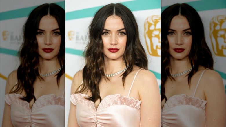 Ana de Armas posing at the EE BAFTA Film Awards 2023 with dark brown hair and subtle brown highlights
