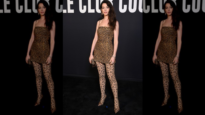 Anne Hathaway posing in a cheetah-print mini dress and matching tights at a Valentino Haute Couture show