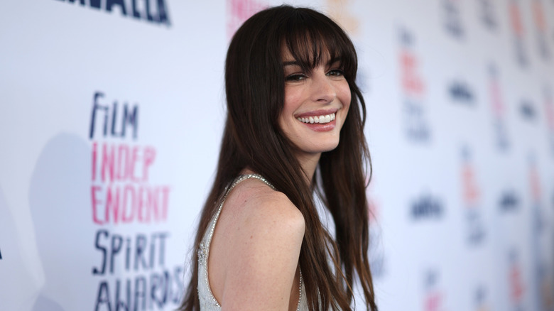 Anne Hathaway laughing while posing at a 2024 film festival