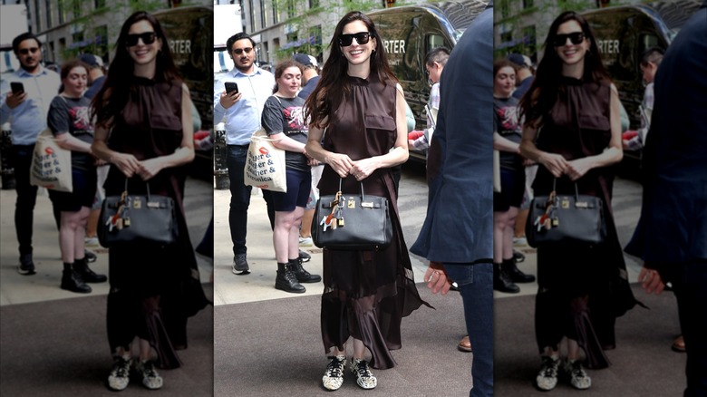 Anne Hathaway pictured in New York City wearing a flowy, brown dress and zebra-printed tennis shoes