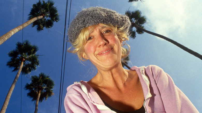 Eve Babitz smiling under palm trees
