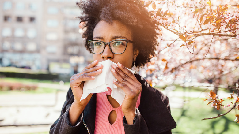 Woman with allergies sneexing