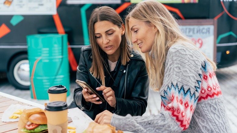 women showing friend phone