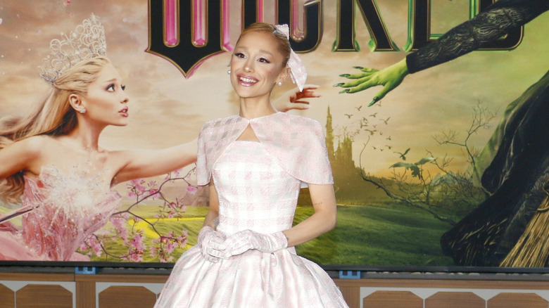 Ariana Grande posing on the red carpet in a pink checked dress the Wicked premiere in LA in November 2024
