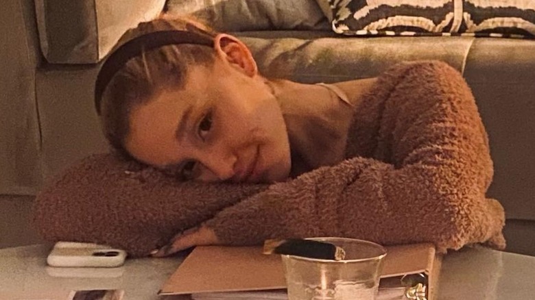 Ariana Grande leaning on her arm without makeup