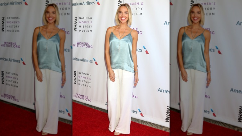 Arielle Kebbel wearing a blue silk top and baggy white pants at the Women Making History Awards in 2018