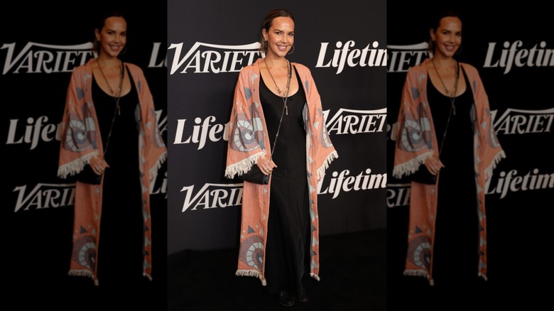 Arielle Kebbel wearing a black dress and a blanket-like cardigan at the Variety Power of Women Nashville in 2025