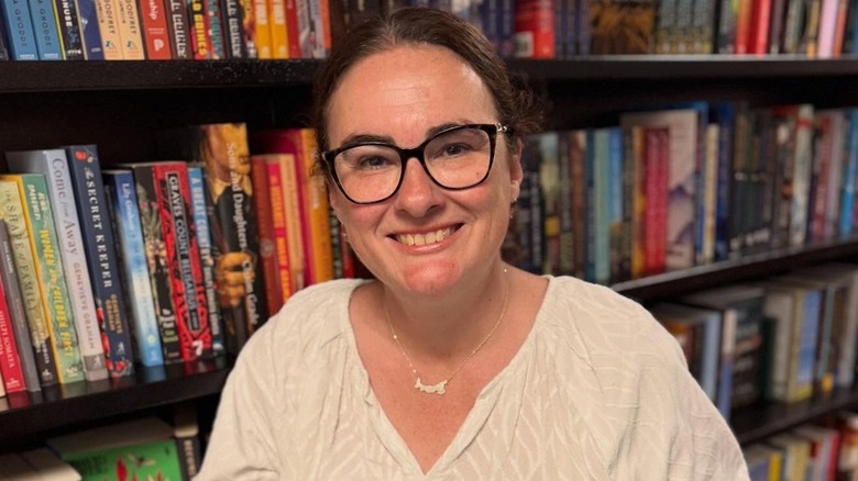 Emma Grey poses for a photo with her books in front of a book shelf in a Barnes & Noble in New York