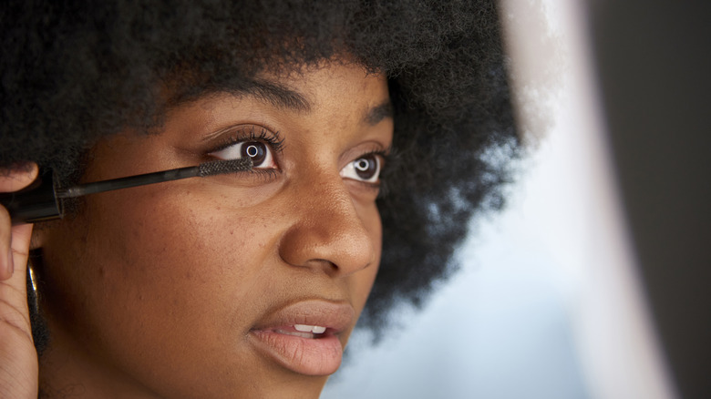 Woman applies mascara