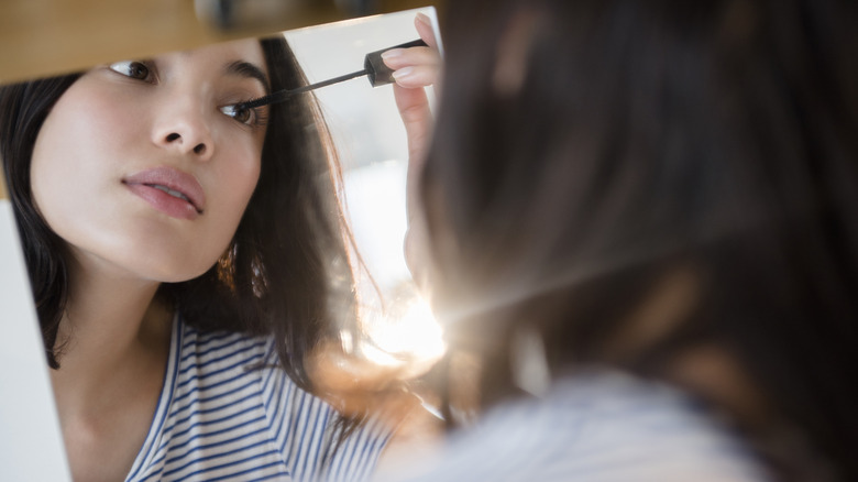 Woman applies mascara