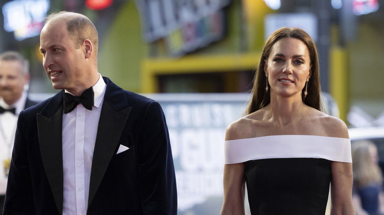 Kate Middleton wears a black dress and Prince William wears a tuxedo