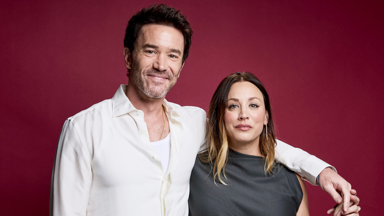 Kaley Cuoco and Tom Pelphrey at an event in front of a red screen