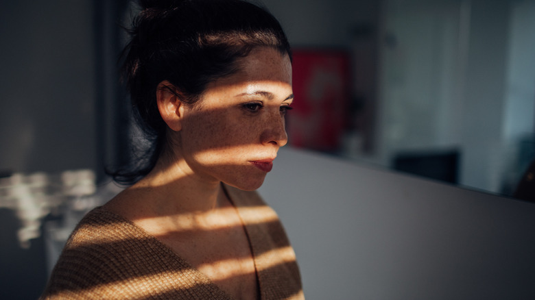 woman sitting in shadows