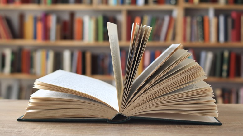 Book open in front of book shelf