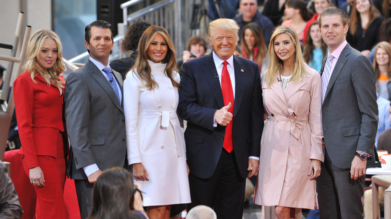 President Donald Trump giving a thumbs up surrounding by Ivanka Trump, Eric Trump, Melania Trump, Donald Trump Jr., and Tiffany Trump