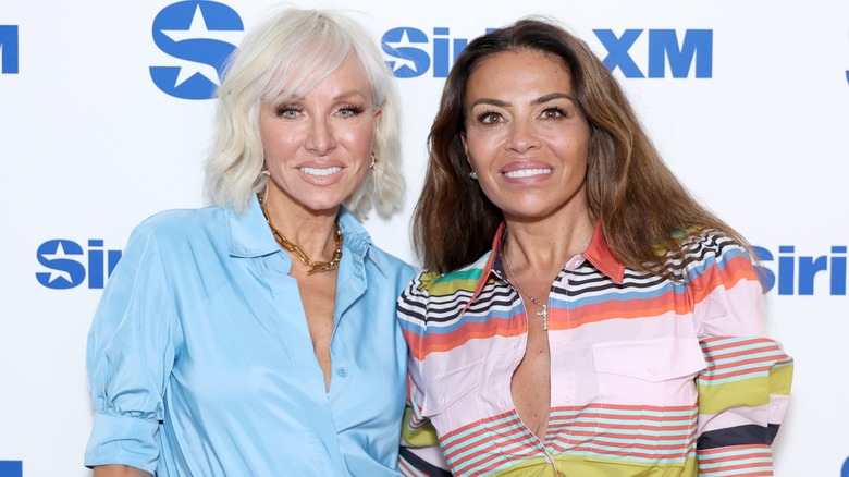 Margaret Josephs and Dolores Catania posing side by side on the red carpet in front of a white background