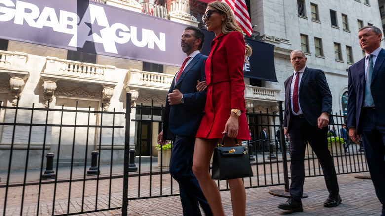 Bettina Anderson in a red skirt suit with Donald Trump Jr walking outside