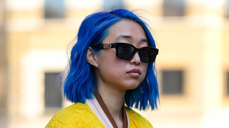 Woman with blue hair wearing sunglasses