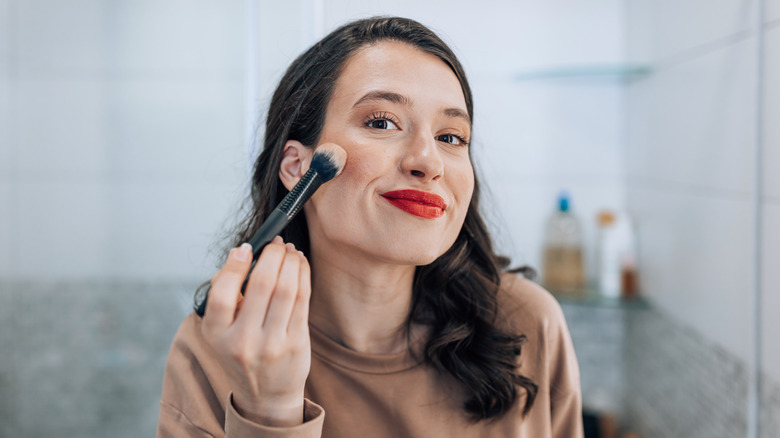 woman putting on blush