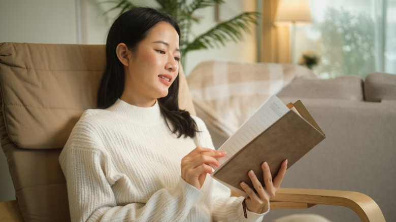 Relaxed young woman enjoying a quiet moment at home while reading a book