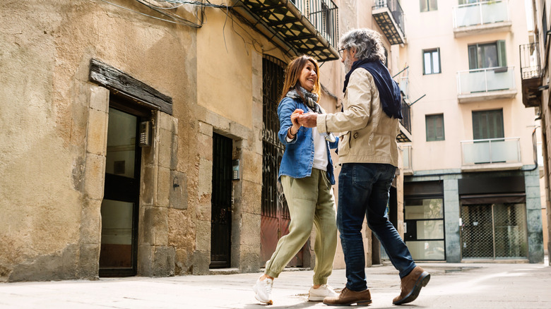 An older couple dance in the street