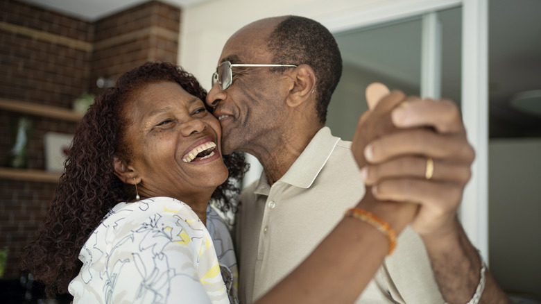 A couple laugh and dance holding hands