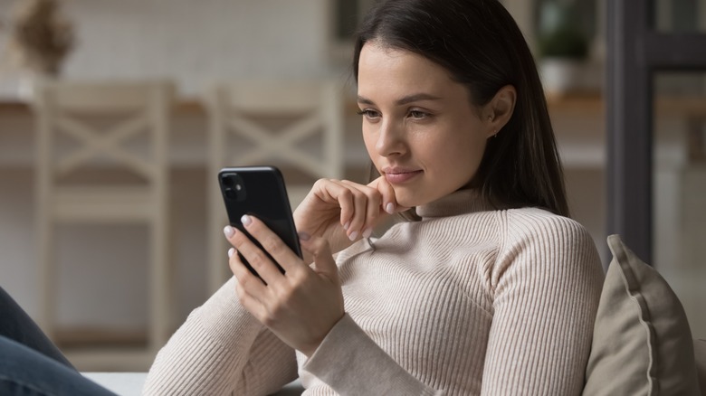 Woman looking at phone serious expression