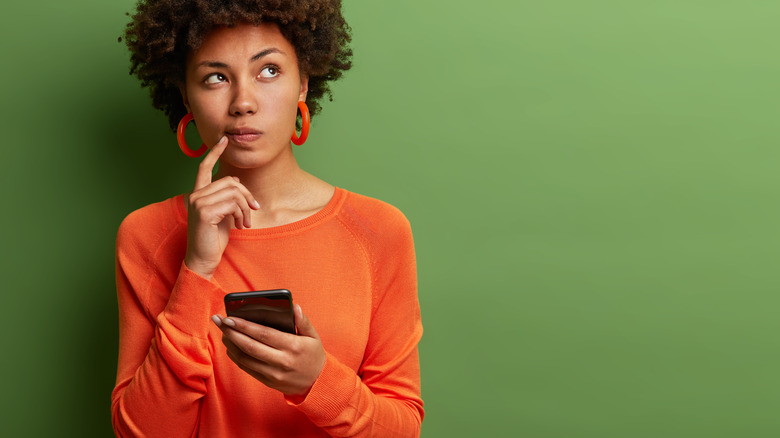 woman holding phone looking up