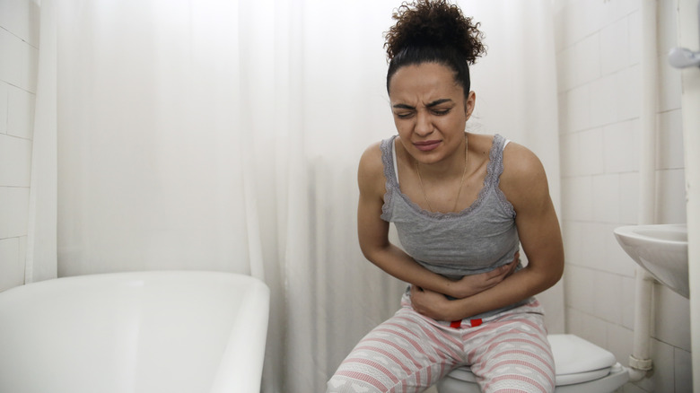 Woman cramping on toilet