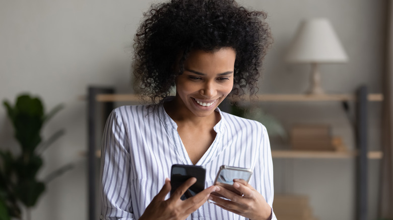 Woman holding two phones