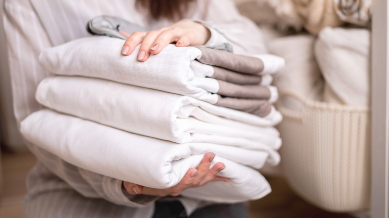 woman holding folding bed linens