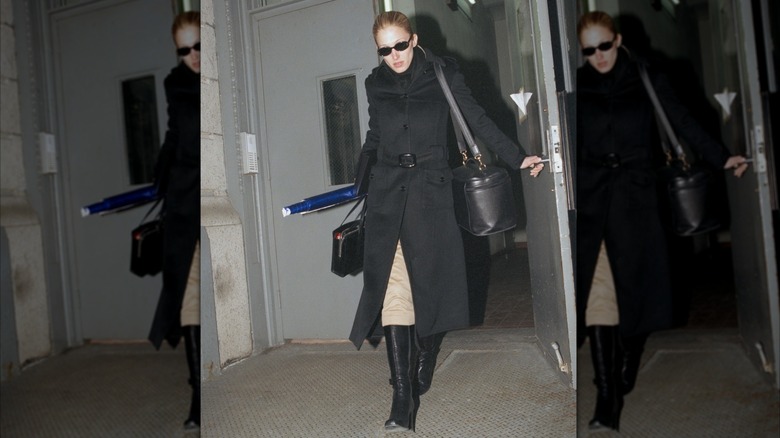 Carolyn Bessette Kennedy in a black coat and black heeled boots in New York