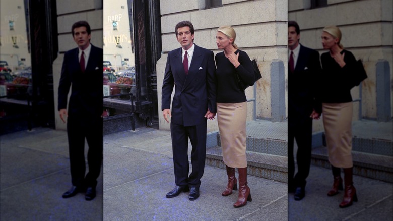Carolyn Bessette Kennedy standing next to John F. Kennedy Jr. in a pencil skirt and boots