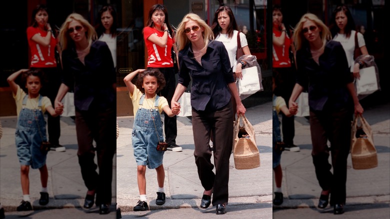 Carolyn Bessette Kennedy walking hand-in-hand with a child