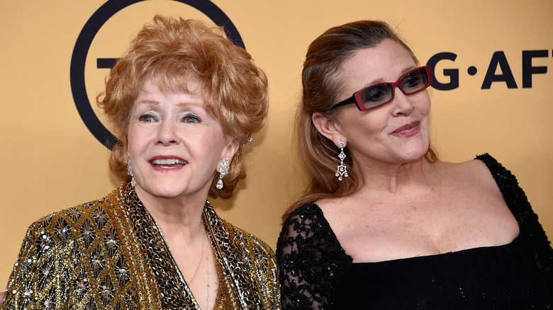 Debbie Reynolds and Carrie Fisher smiling on the red carpet together in 2015