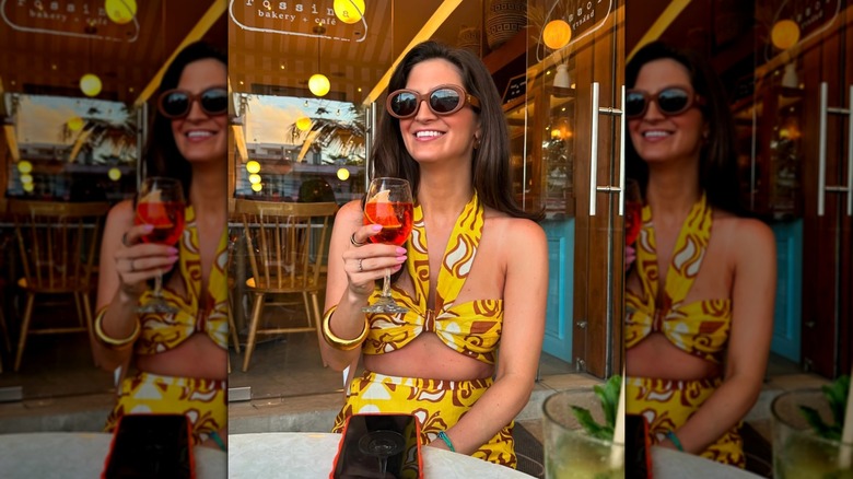 Kaitlan Collins posing for a photo with a drink in her hand in Mexico