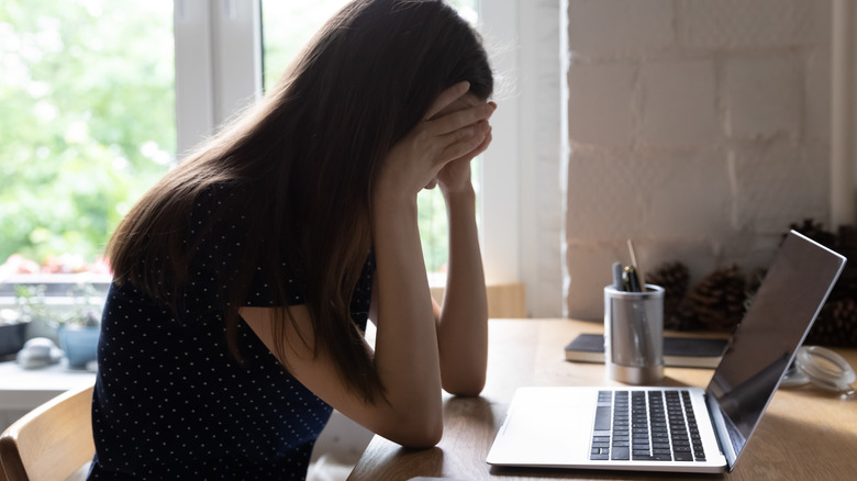 Woman looking at computer upset