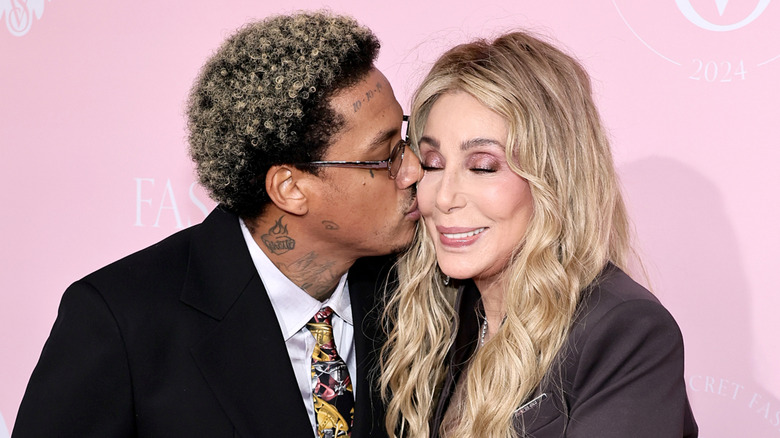 Alexander "A.E." Edwards plants a kiss on Cher's cheek at the Victoria's Secret Fashion Show in 2024.
