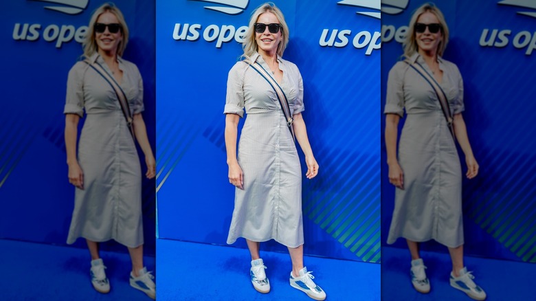 Chelsea Handler in a long shirt dress with metallic sneakers, posing on the blue carpet