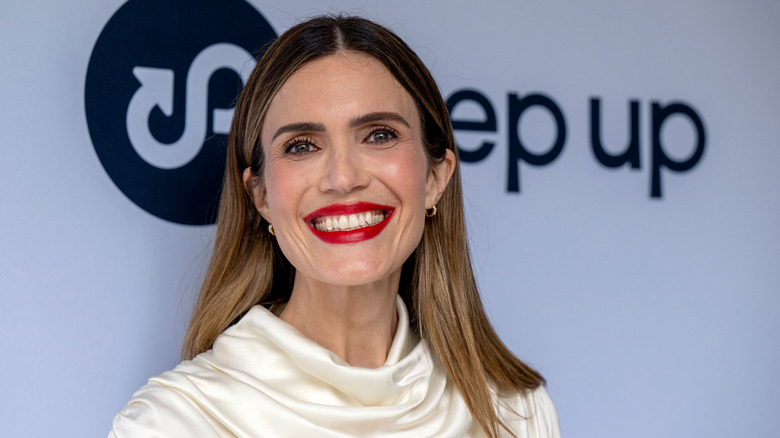 Mandy Moore at an event with red lipstick and a white blouse