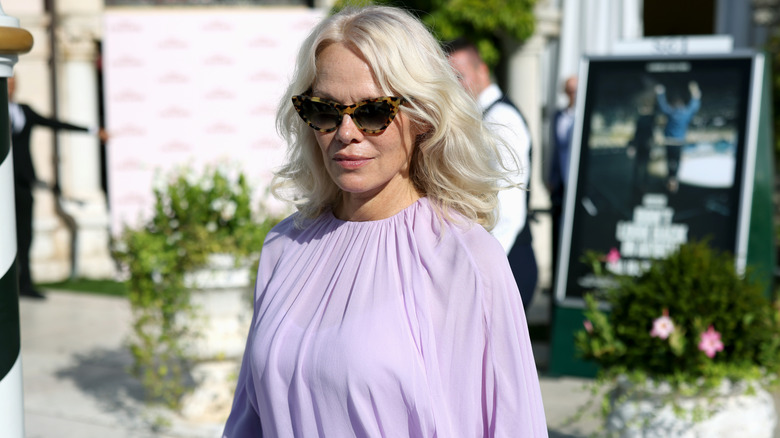 Pamela Anderson pictured walking during the Venice International Film Festival while wearing cat-eye sunglasses and a lavender dress