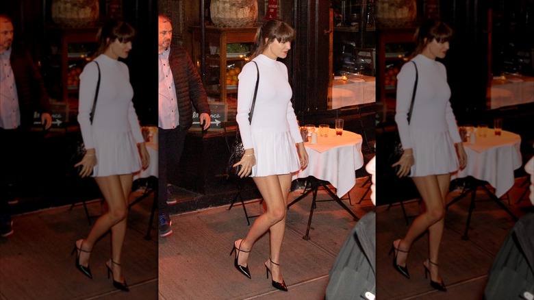 Taylor Swift on the street in a white minidress